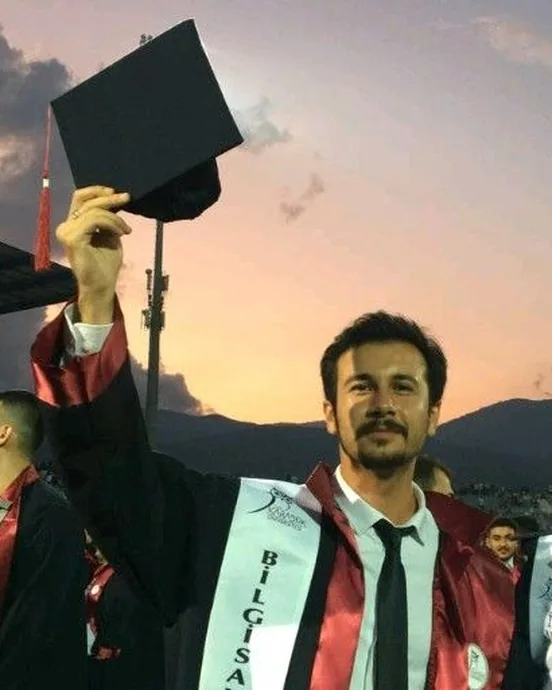 Sinan at his graduation, cap raised against a sunset sky